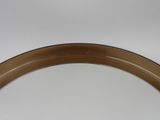 a round mirror with a brown rim on a white wall