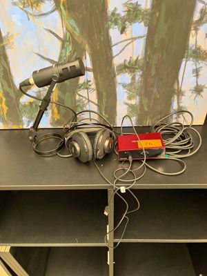 deux microphones posés sur une table, avec un tableau en arrière-plan