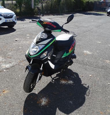 a motorcycle parked in a parking lot with a car in the background