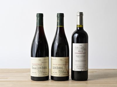 trois bouteilles de vin sont alignées sur une table en bois