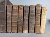 several old books are stacked on top of each other on a table