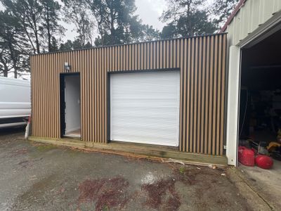 une photo d'un garage devant lequel est garée une camionnette blanche