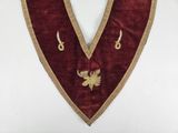 a close up of a red and gold apron