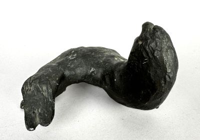une sculpture noire représentant un chien sur une surface blanche