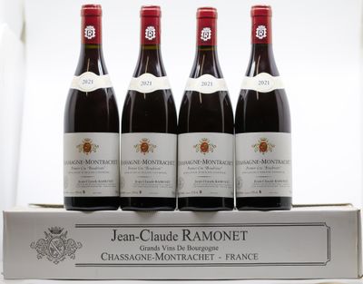 quatre bouteilles de vin rouge posées sur une boîte blanche