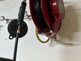 a red fire hydrant hanging from a wall next to a tire