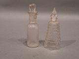 two glass bottles sitting next to each other on a table
