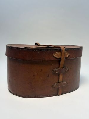 une vieille boîte en cuir marron, entourée d'une lanière en cuir