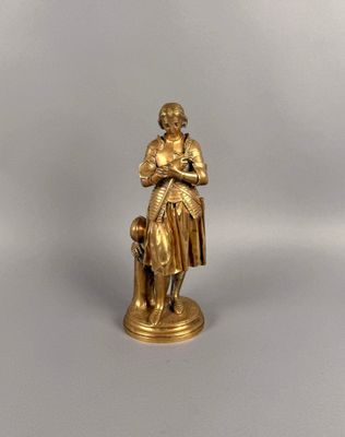 figurine en or représentant une femme avec un chien, sur fond blanc