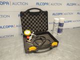 an open case with a pressure gauge and a hose in it