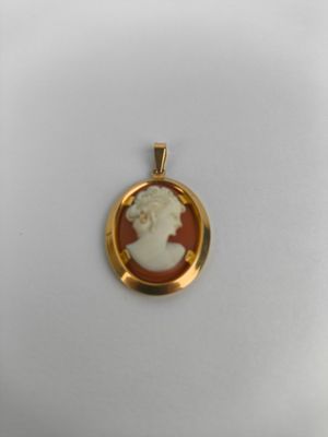 un gros plan d'un pendentif plaqué or représentant une femme