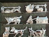 a black box with silver metal figurines of animals and people