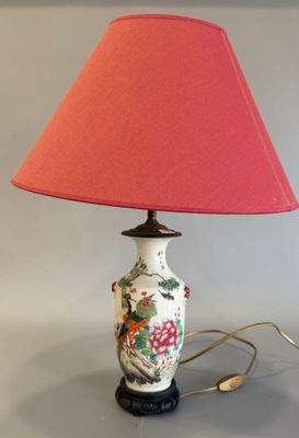 une lampe surmontée d'un abat-jour rose