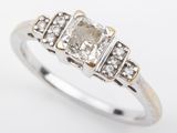 a white gold ring with a diamond and three small diamonds