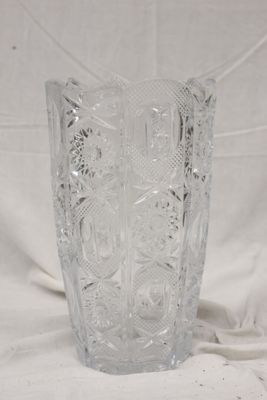 un vase en verre sur un tissu blanc avec un fond blanc