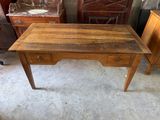 a wooden desk with drawers and a mirror in the corner