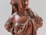 a bronze bust of a woman with a flowered head on a clear base