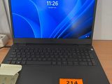 un ordinateur portable posé sur un bureau à côté d'un téléphone