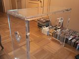 a clear table with a glass top on a hard wood floor