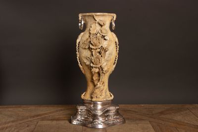 un vase posé sur une table à fond noir