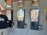 un homme qui se tient devant un distributeur automatique