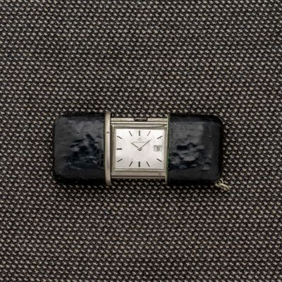 une petite montre posée sur un morceau de tissu