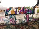 someone is holding a purse with a floral pattern on it