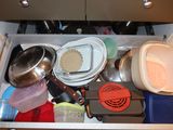 a drawer full of pots and pans in a kitchen