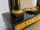 a black and gold clock sitting on top of a table