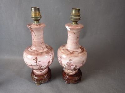 deux vases roses posés l'un à côté de l'autre sur une table