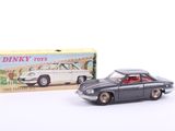 toy car in front of a box of dinky toys on a white surface