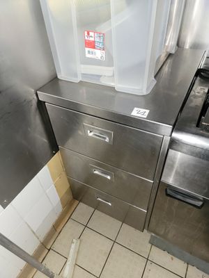 une poubelle posée sur une armoire métallique dans une cuisine