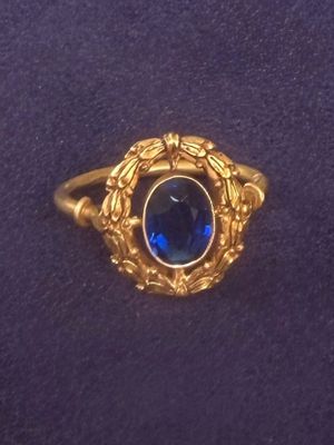 an image of a gold ring with a blue stone in the center