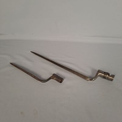 une paire de vieux outils en métal posés sur une surface blanche
