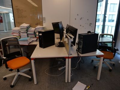 un bureau avec deux ordinateurs et une chaise dans la chambre