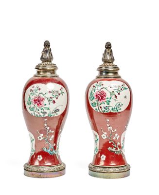 pair of red vases with floral designs on them on a white surface
