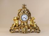 a gold clock sitting on top of a table