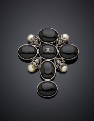 une broche en noir et blanc ornée de perles sur fond noir