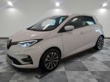 une voiture blanche est garée dans une pièce au sol à carreaux