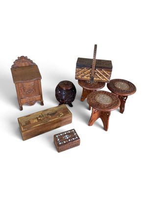 une petite collection de meubles miniatures en bois posés sur une surface blanche