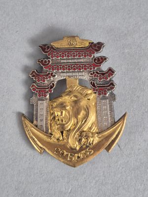 une image représentant une broche dorée et rouge ornée d'un lion