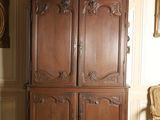 a large wooden cabinet in a room with a chair