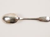 a silver spoon and a spoon rest on a white surface