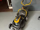 a yellow and black lawn mower sitting on the floor