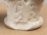 a white vase sitting on top of a wooden table