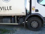 un gros camion blanc garé sur le bord de la route