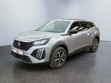 Le SUV argenté est garé dans une pièce au sol noir.