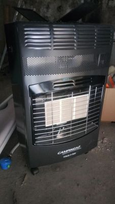 a black heater sitting on the floor next to a cardboard box