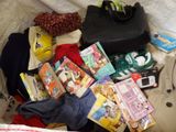 a pile of clothing and other items on a bed
