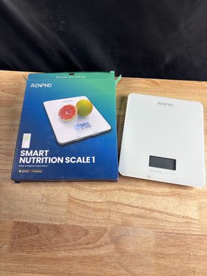 une photo montrant une boîte contenant une balance nutritionnelle intelligente à côté d'une boîte de fruits